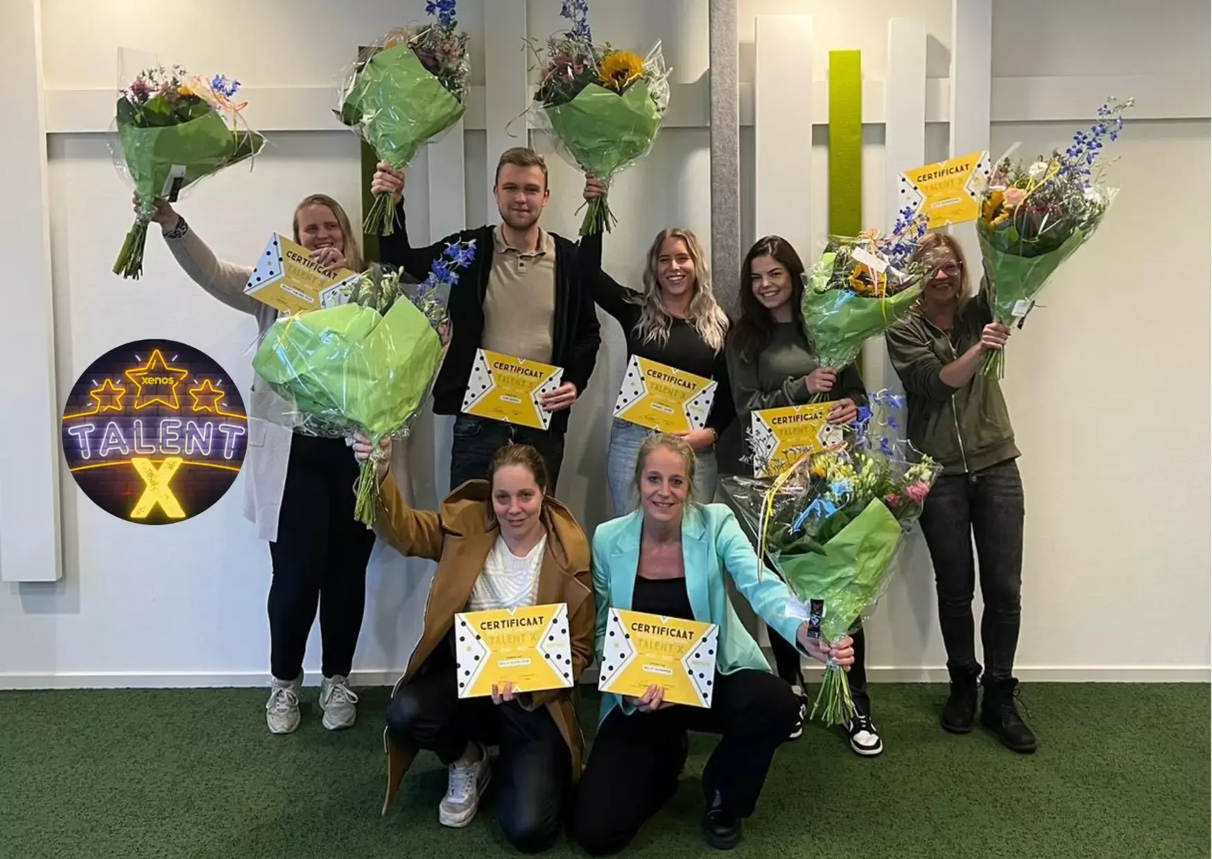 Een jonge medwerker in een winkel staat achter een tafel en vouwt denim broeken. Ze heeft een glimlach op haar gezicht.