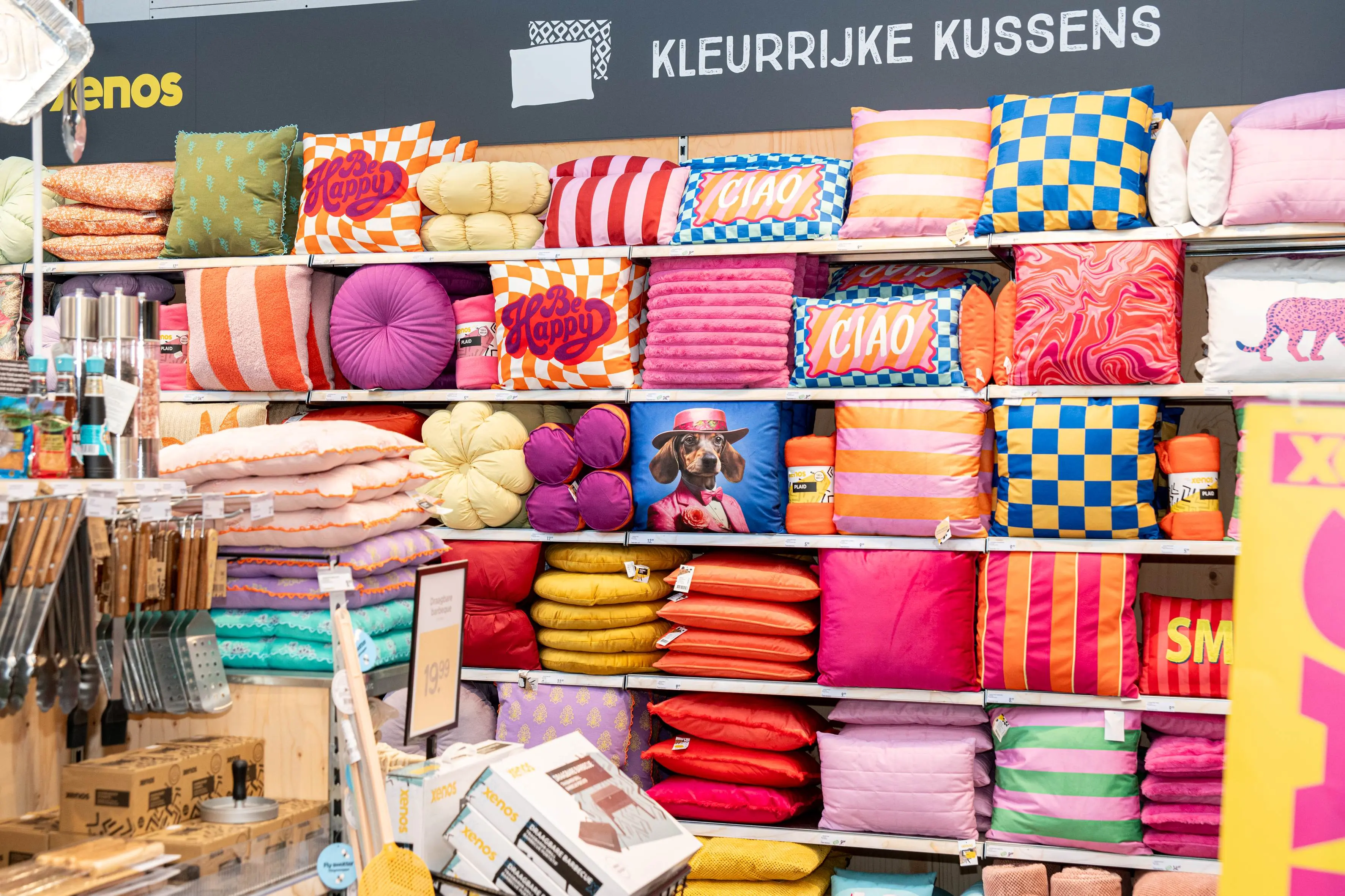 Vrouw in winkel glimlacht met een mobiel in haar hand.